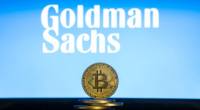 moeda de Bitcoin à frente do logotipo do Goldman Sachs