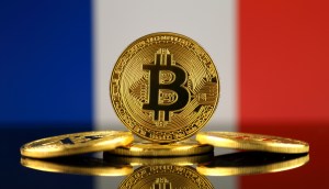 Moedas de Bitcoin diante de bandeira da França