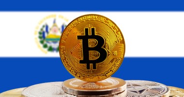 Moeda de Bitcoin à frente de bandeira de El Salvador