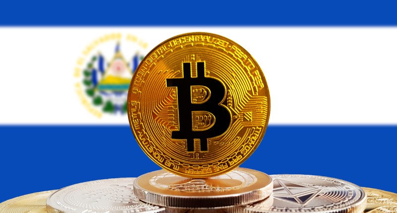 Moeda de Bitcoin à frente de bandeira de El Salvador