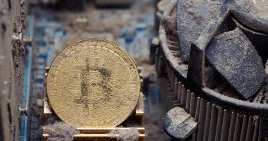 Moeda de bitcoin entre placa de computador aparatemente enferrrujados