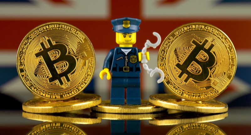 miniatura de soldado em em meio a moedas de Bitcoin-ao fundo, bandeira da Inglaterra