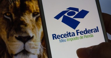 Smartphone mostra logotipo da Receita Federal; ao fundo, um leão