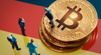 miniaturas de homens e moedas de bitcoin em cima de bandeira da Alemanha