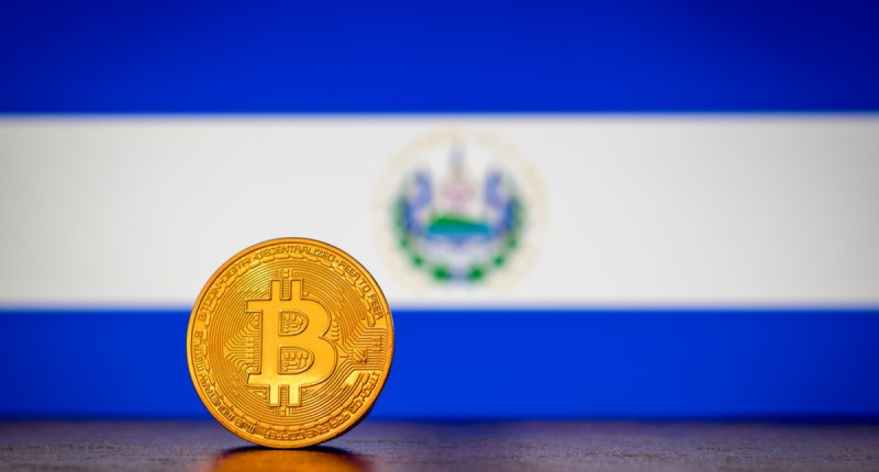 Moeda de Bitcoin à frente de bandeira de El Salvador