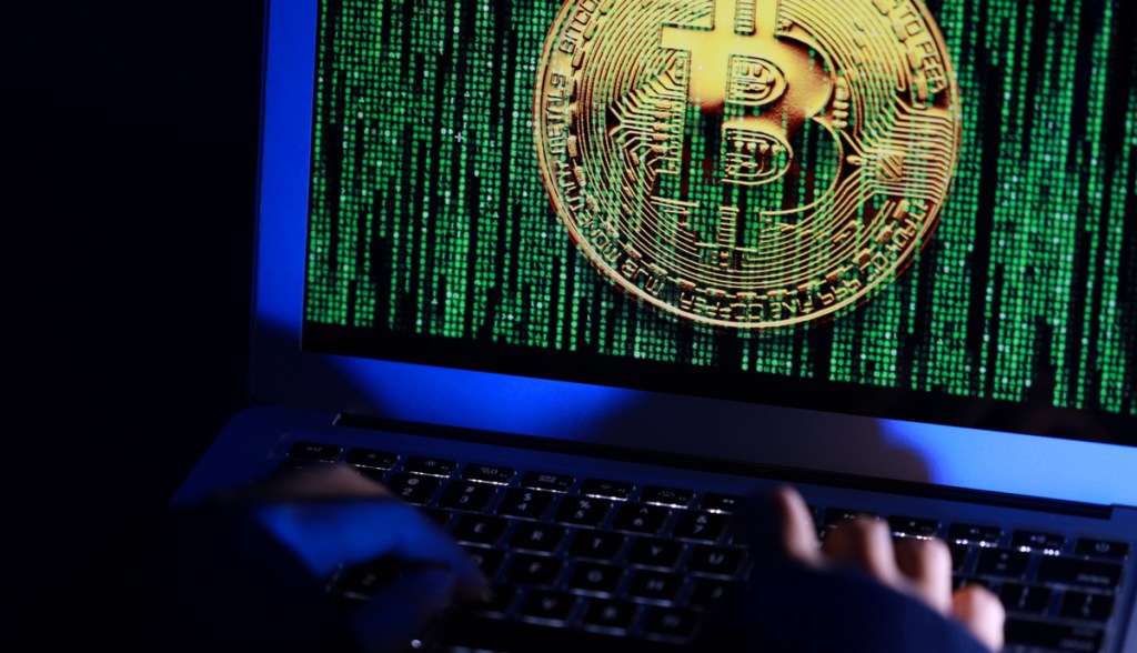 tela mostra moeda de bitcoin em meio a chuva de dados a la matrix