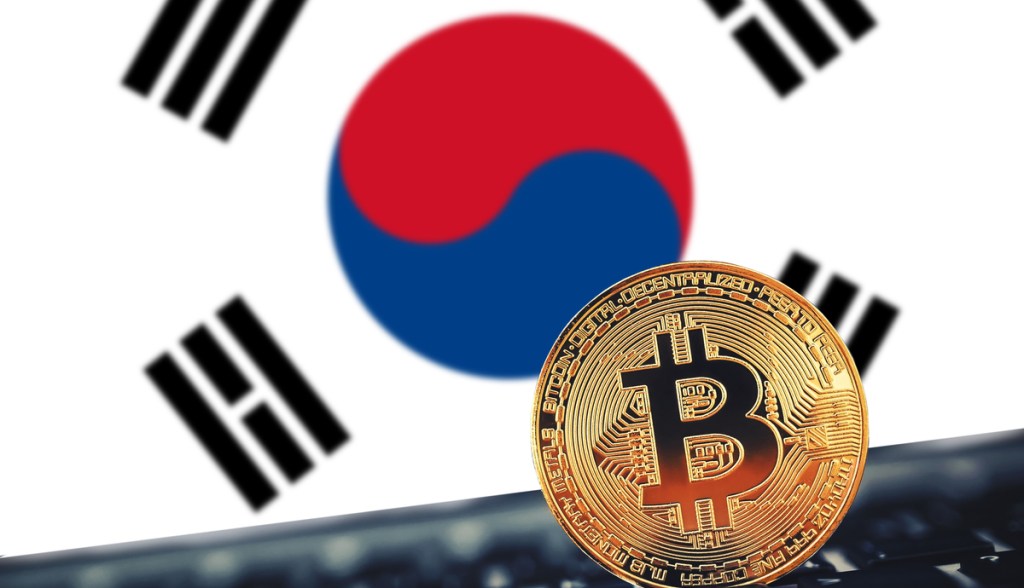 moeda de bitcoin à frente de tela que mostra bandeira da Coreia do Sul