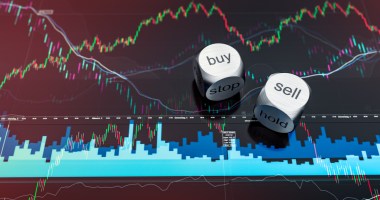 Dados metálicos com indicação buy e sell em cima de tela de trading