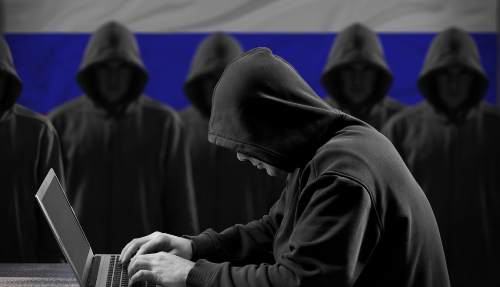 Homem hacker com capuz preto mexendo no computador para cibercrime .jpg