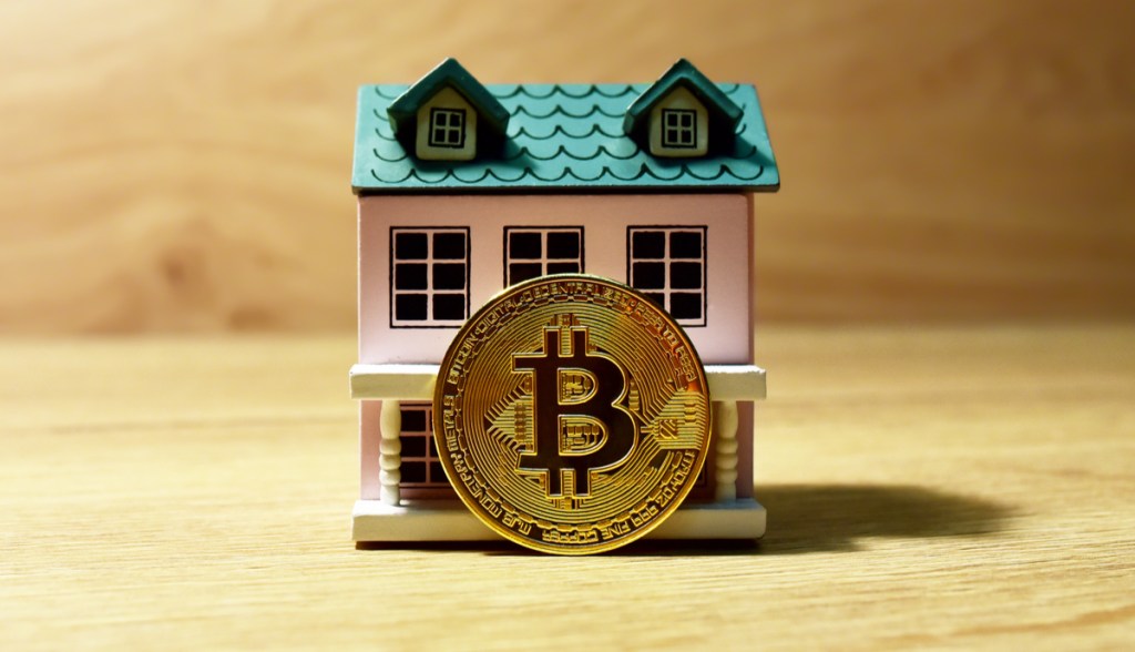 Modelo de casa com uma moeda de bitcoin