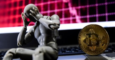 um robô triste sentado na frente do bitcoin em crise