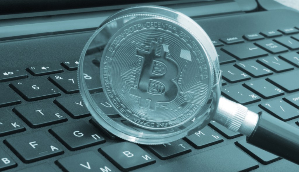 Lente de aumento, bitcoin e computador