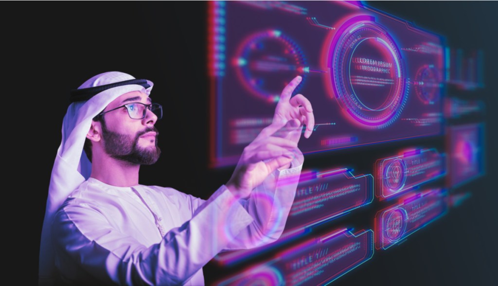 Homem barbado com kandura opera um holograma