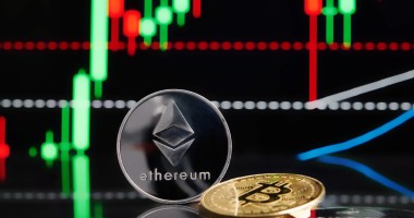 Moedas de Ethereum e Bitcoin em frente a um gráfico de candles em uma tela