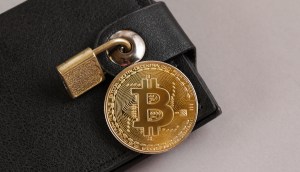 moeda de bitcoin em cima de uam carteira de bolso fechada com um cadeado