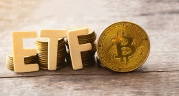 Letras que formam a sigla ETF próximas a uma moeda dourada de Bitcoin (BTC)