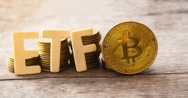 Letras que formam a sigla ETF próximas a uma moeda dourada de Bitcoin (BTC)