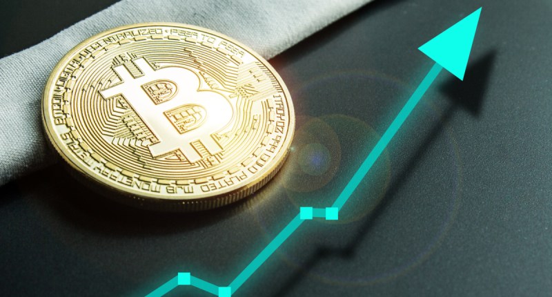 Moeda dourada de Bitcoin (BTC) próxima a uma seta que indica uma alta nos preços