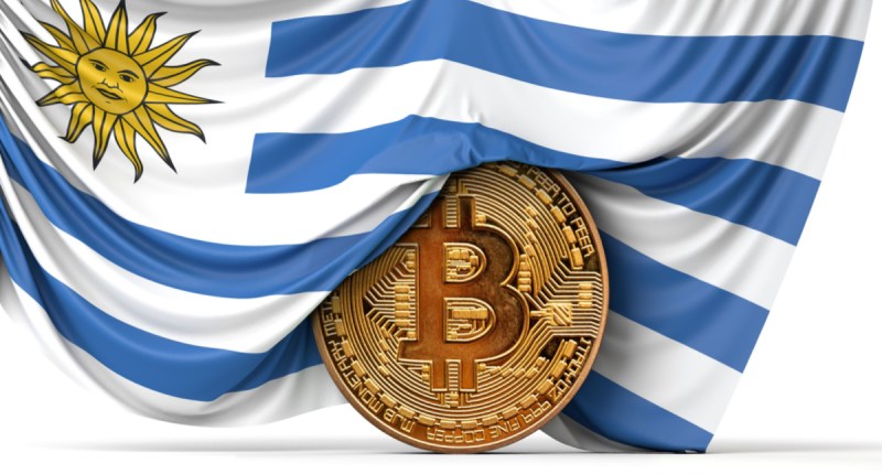 Moeda de bitcoin semicoberta por bandeira nacional do Uruguai