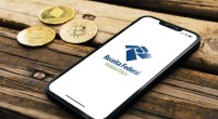 Celular com logo da Receita Federal e Bitcoin e criptomoedas do lado