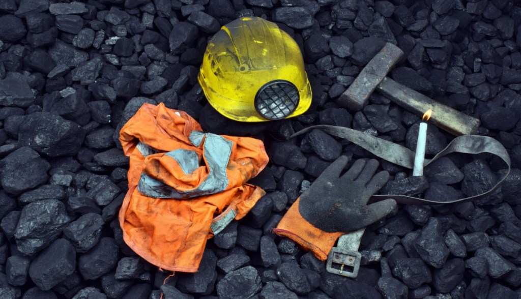 roupas de minerador sobre monte de carvão