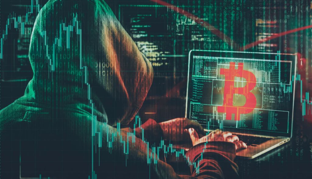 hacker no computador com logo do bitcoin