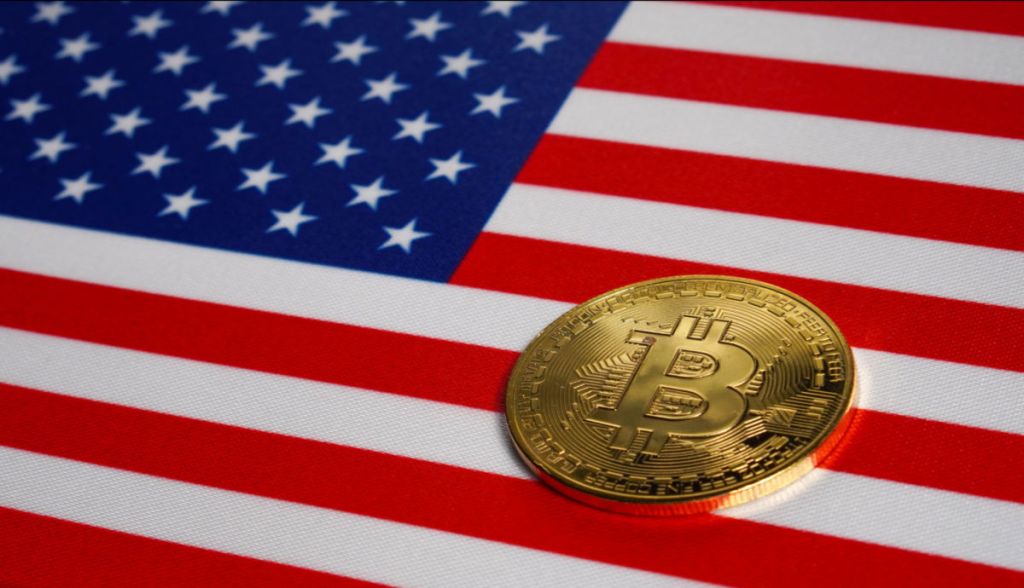 moeda de bitcoin em cima de uma bandeira dos EUA