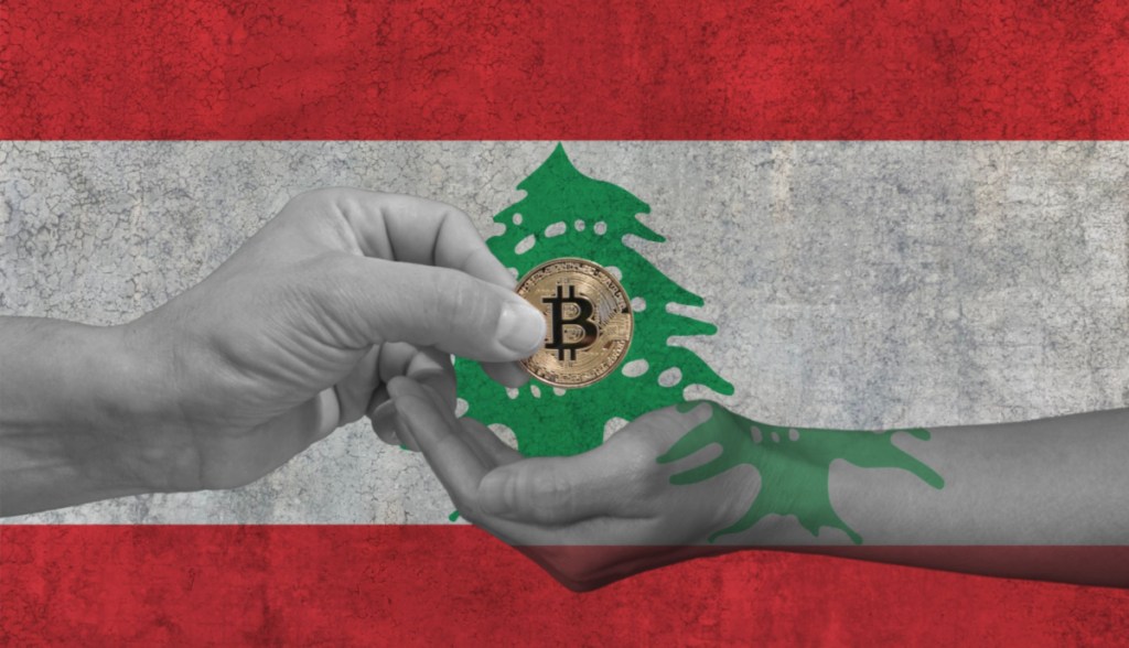 mãos trocando uma moeda de bitcoin BTC à frente de uma bandeira do Líbano