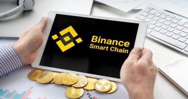 Uma perssoa segura um tablet com logo da Binance Smart Chain