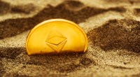 Moeda Ethereum ETH parcialmente enterrada na areia