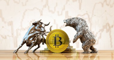 Moeda de bitcoin entre as estátuas de um touro e de um urso