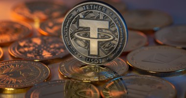 Moeda de Tether apoiada sobre outras deitadas