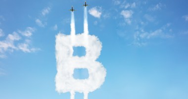 Dois aviões riscam com fumaça para cima o B de bitcoin