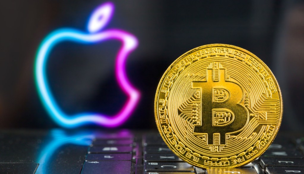 Moeda de Bitcoin sobre teclado de laptop-ao fundo, logo colorido da Apple