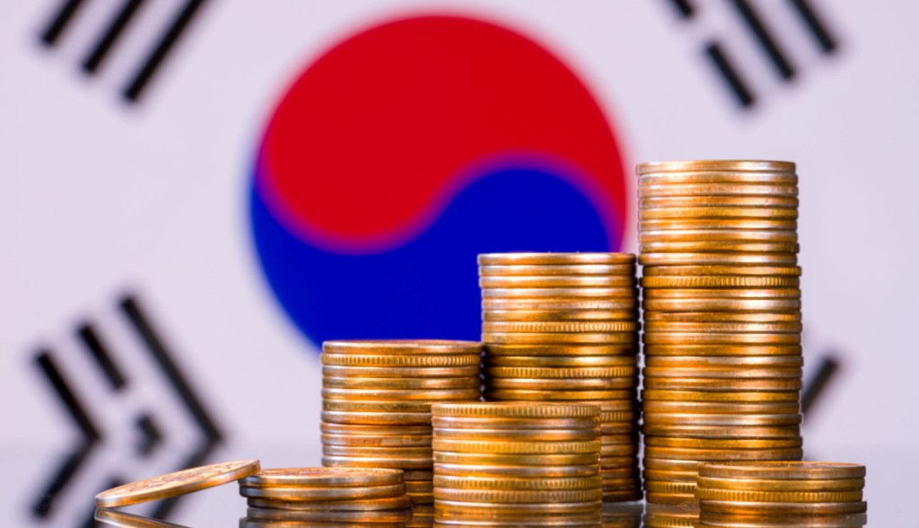 cabidela, ou pilha de moedas, à frente de bandeira da Coreia do Sul