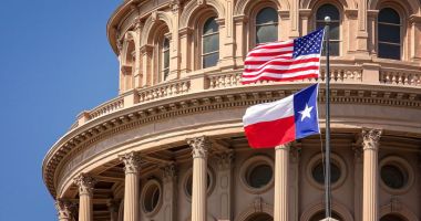 Bandeiras dos EUA e do estado do Texas no edifício do Capitólio em Austin