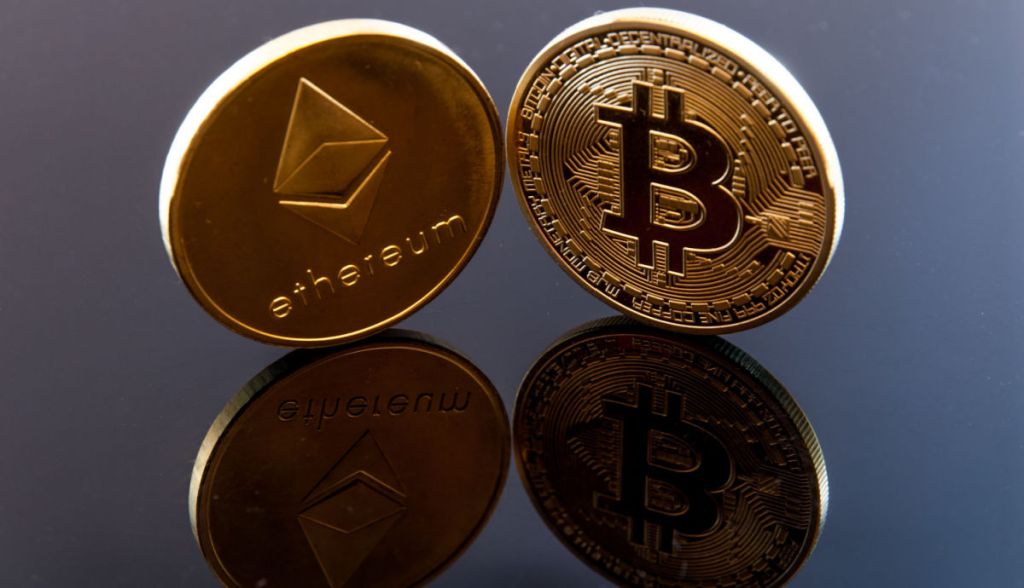 moedas de bitcoin e ethereum sobre mesa envernizada