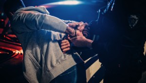 Policial algemando suspeito durante a noite