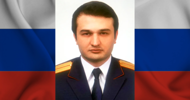 Foto do ex-investigador Russo Marat Tambiev com a bandeira da Rússia ao fundo