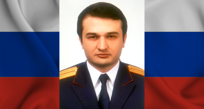 Foto do ex-investigador Russo Marat Tambiev com a bandeira da Rússia ao fundo