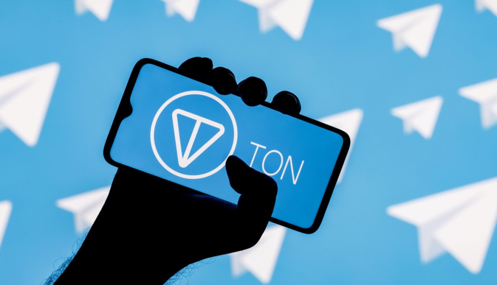 Ilustração de mão segurando smartphone com logotipo da Toncoin