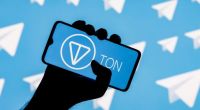 Mão segurando celular com logo da Toncoin e no fundo ícones do Telegram