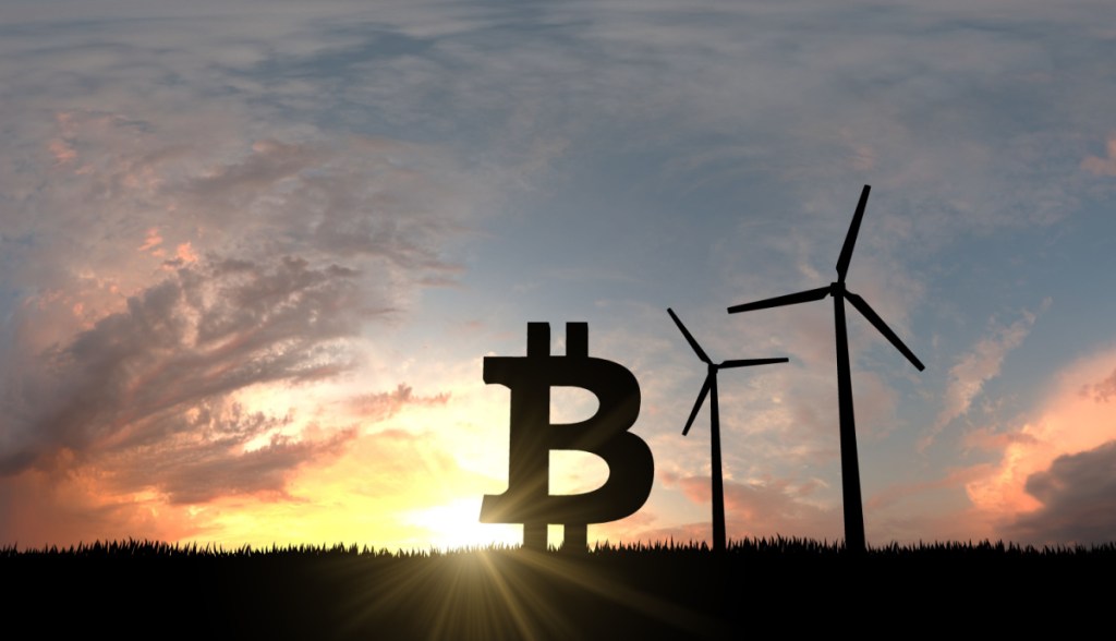 Símbolo do Bitcoin à altura de cataventos no topo de um morro à frente da luz do Sol