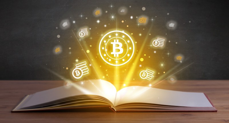 logo do bitcoin em cima de livro