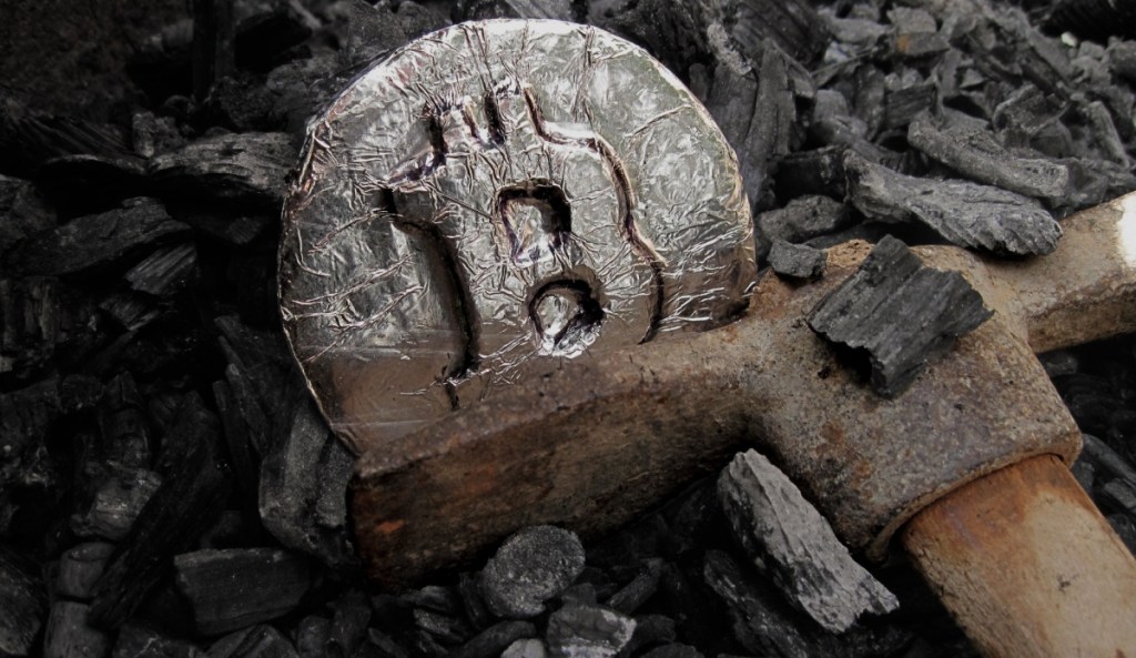 Moeda de Bitcoin de prata no meio da carvão de mineração