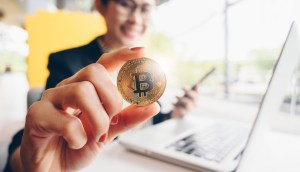 mulher desfocada mostra moeda de bitcoin