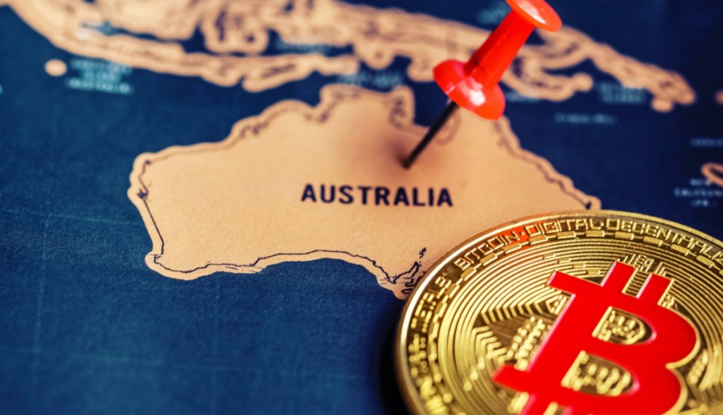 Moeda de bitcoin ao lado de mapa da Austrália