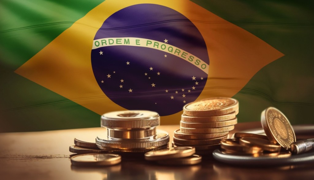 Moedas douradas à frente de bandeira do Brasil