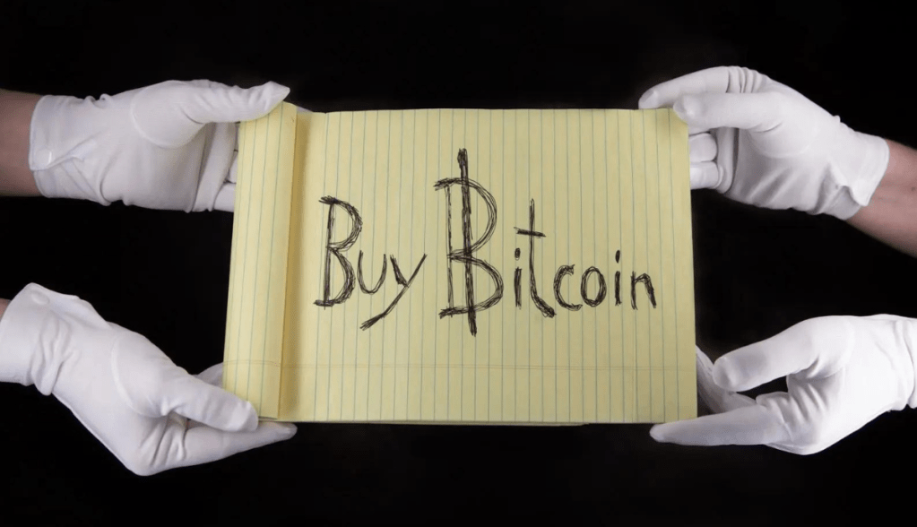 Imagem da matéria: Icônico papel escrito “Compre Bitcoin” é vendido por R$ 5,1 milhões em leilão