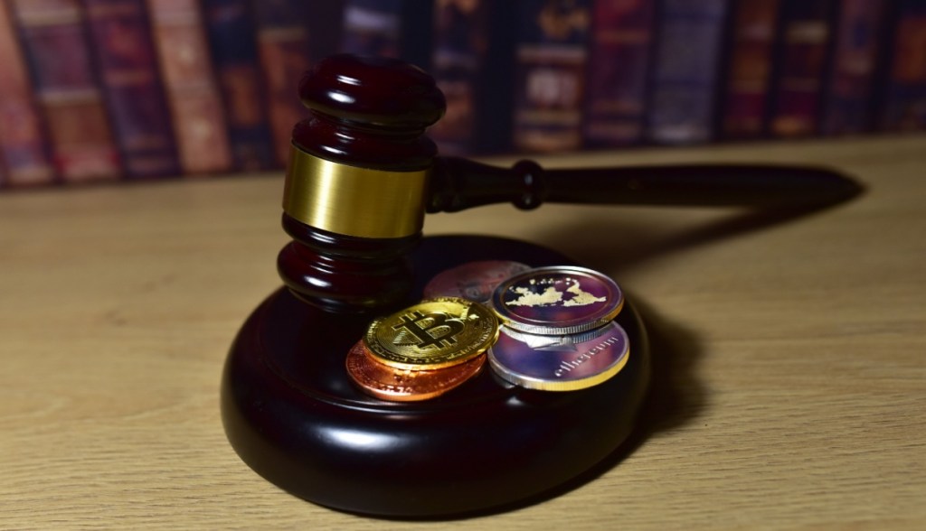martelo de juiz e criptomoedas sobre mesa